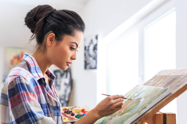 istock Side view of young woman drawning in workshop 643035170