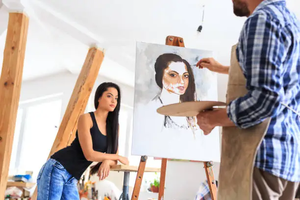 Photo of Artist making portrait of young woman