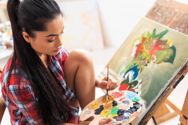 istock Young woman sitting and drawing nature morte 643035356