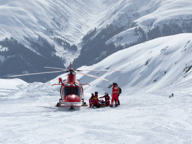 swiss air rescue helicopter next to injured skier on ski piste - skiing snow sport mountain imagens e fotografias de stock