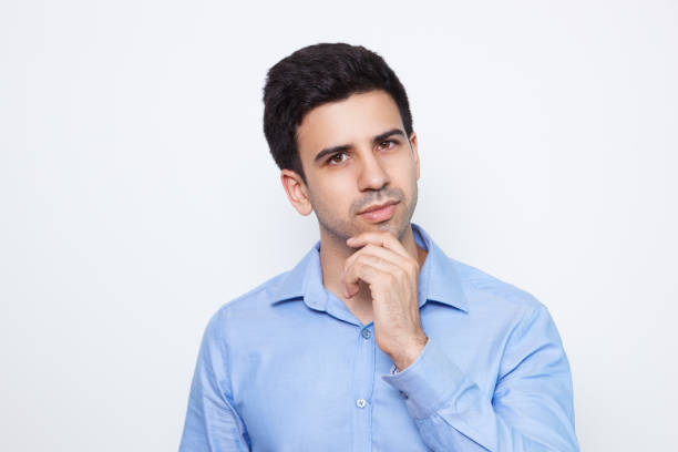 istock Pensive Young Handsome Man Touching Chin 643038964