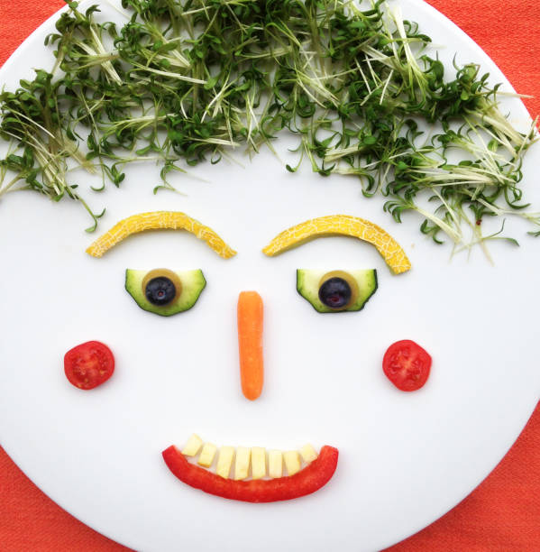 istock Quirky Moments:Funny food face made with vegetables and fruit and placed on a white plate 643042872
