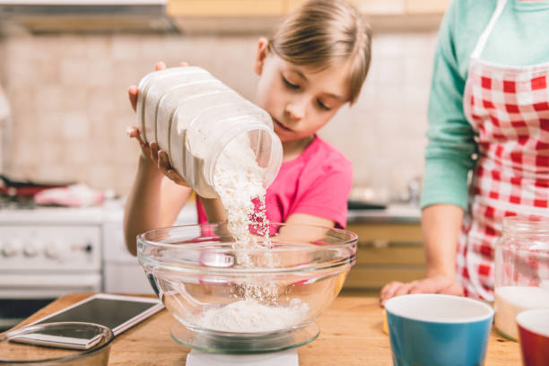 istock Daughter helping mother to making  pizza dough 643042972