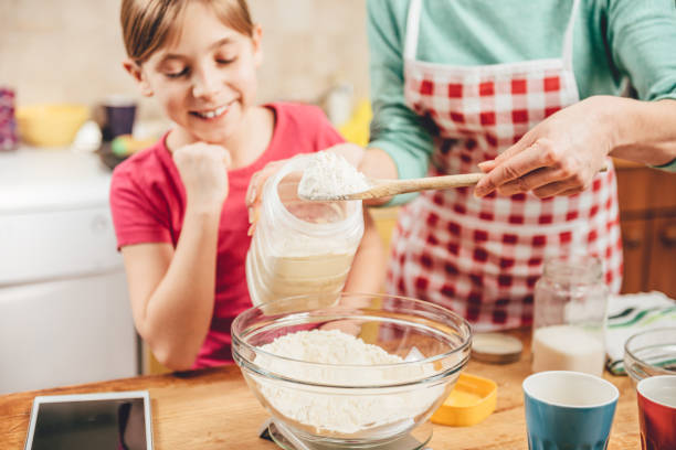 istock Daughter helping mother to making  pizza dough 643042996
