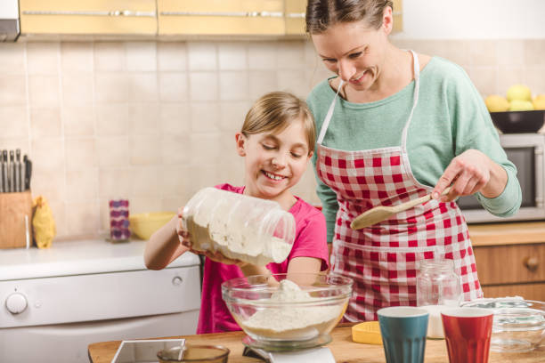 istock Daughter helping mother to making  pizza dough 643043038