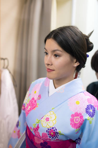 istock Young woman in kimono making up in fitting room 643043084