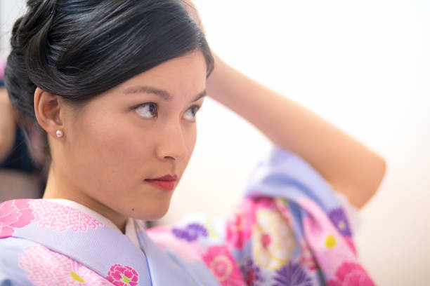 Young Austrian woman in Kimono making up in fitting room