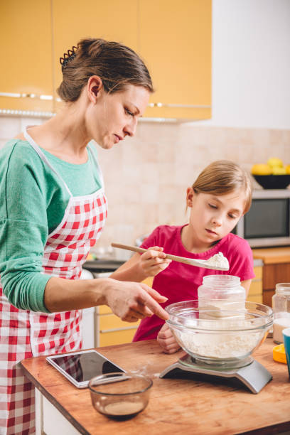 istock Daughter and mother making  pizza dough 643043200