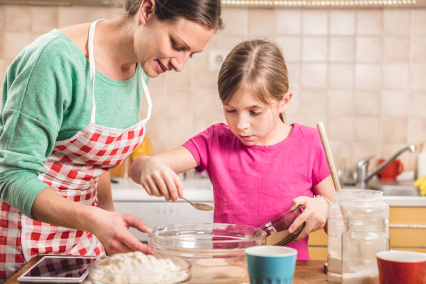 istock Daughter and mother making  pizza dough 643043308