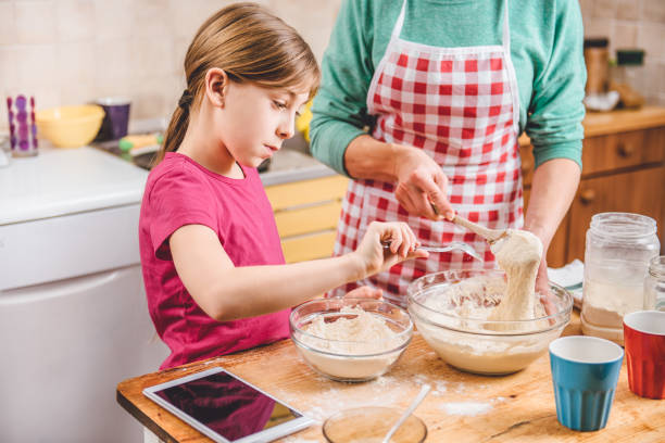 istock Daughter and mother making  pizza dough 643043382