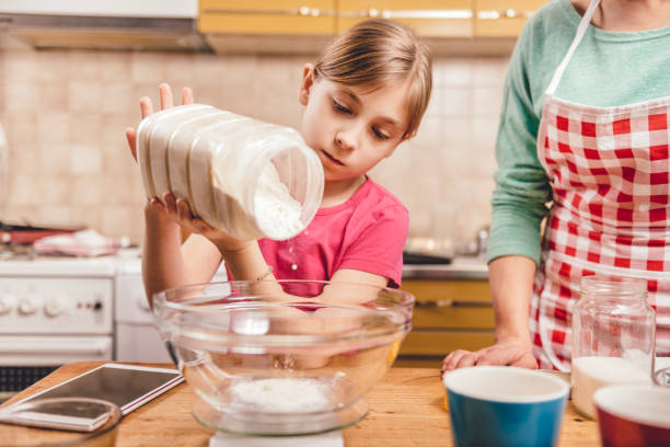 istock Daughter helping mother to making  pizza dough 643047900