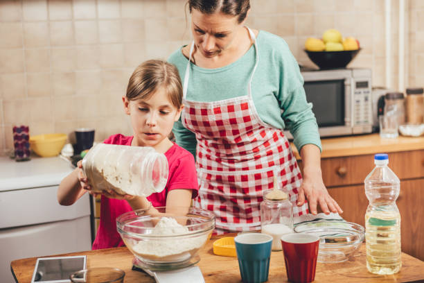 istock Daughter helping mother to making  pizza dough 643047936