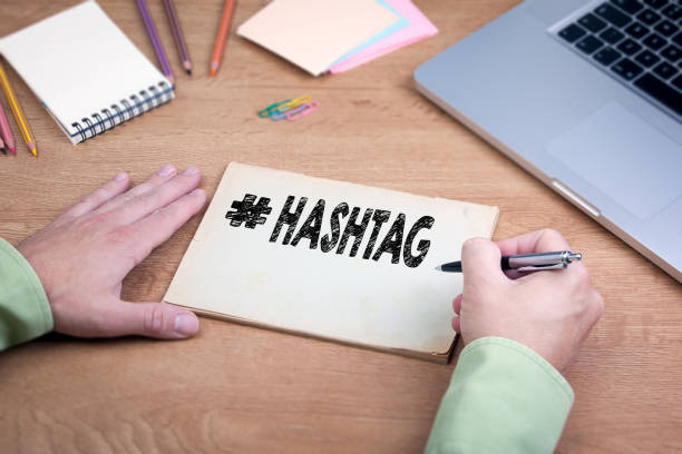 istock Hand writing Hashtag. Office desk with a laptop and stationery 643050936
