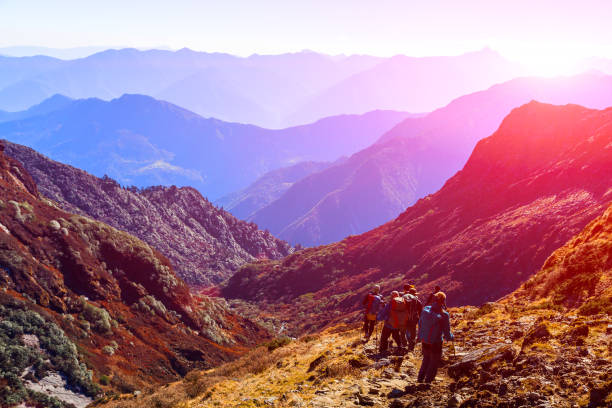 istock Group of People with Backpacks walking on Trail sunny saturated 643060044