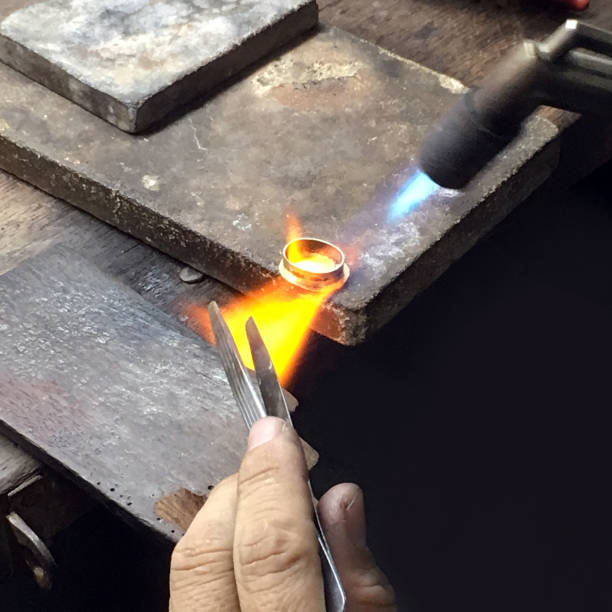 istock A gold making worker is firing on the gold ring 643080902