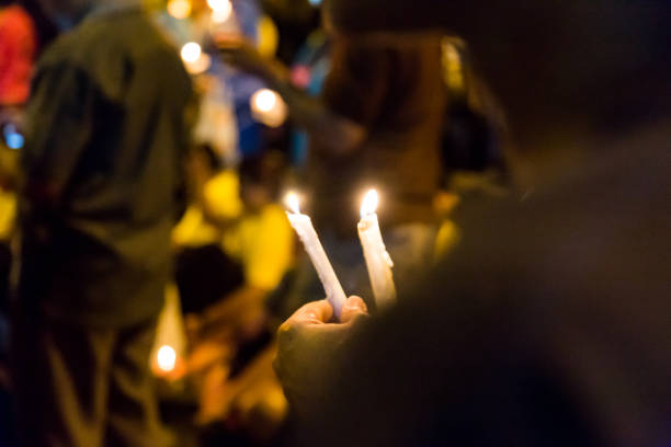 istock People holding candle vigil in darkness 643081004