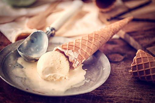 Homemade vanilla ice cream in a cone. This creamy delicious ice cream is a perfect treat on a sunny day.