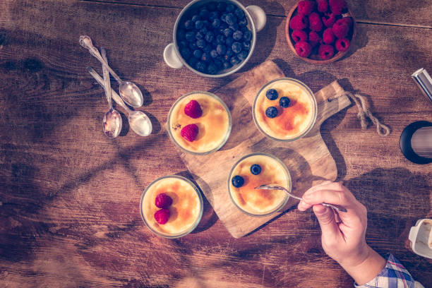 Preparing Homemade Creme Brulee with fresh berries