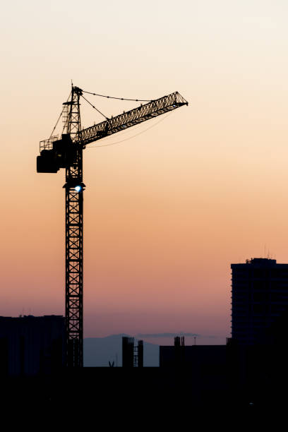 istock Construction site with silhouettes of cranes on the sunset background 643089942
