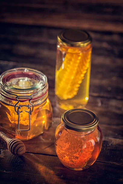 Honey in jar with honeycomb on wooden background