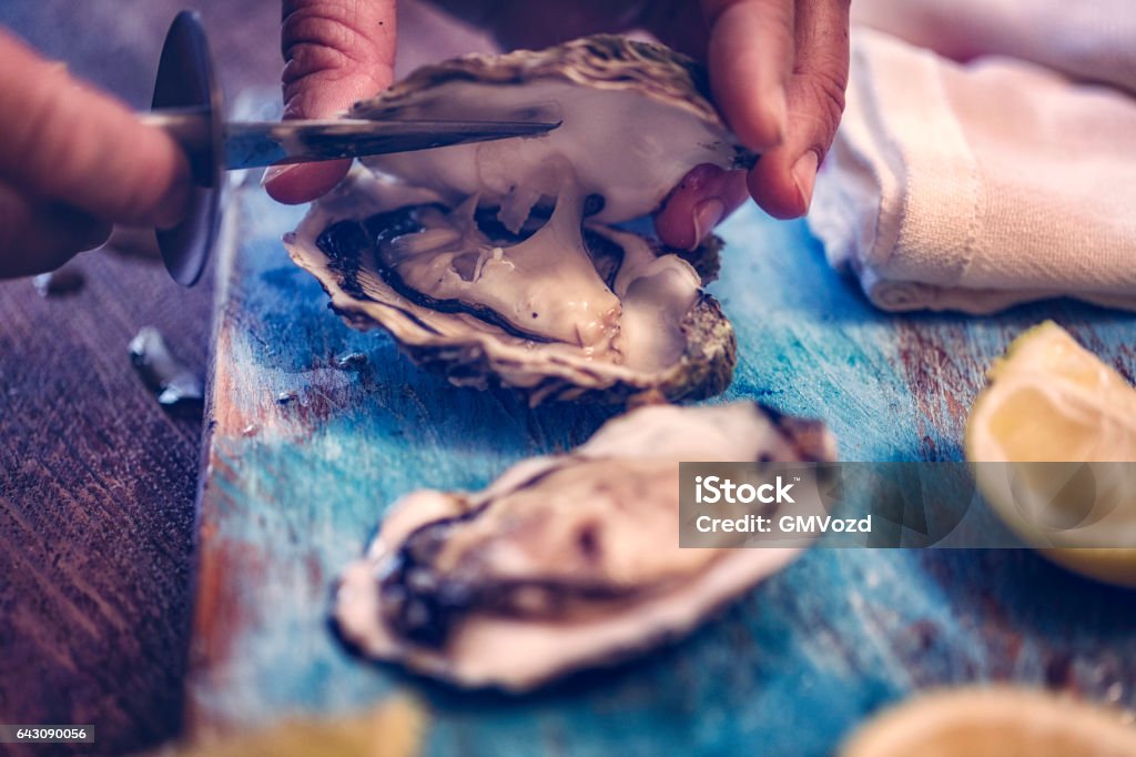 Oysters on plate with ice and lemon Oysters served on a plate with ice and lemon Oyster Stock Photo