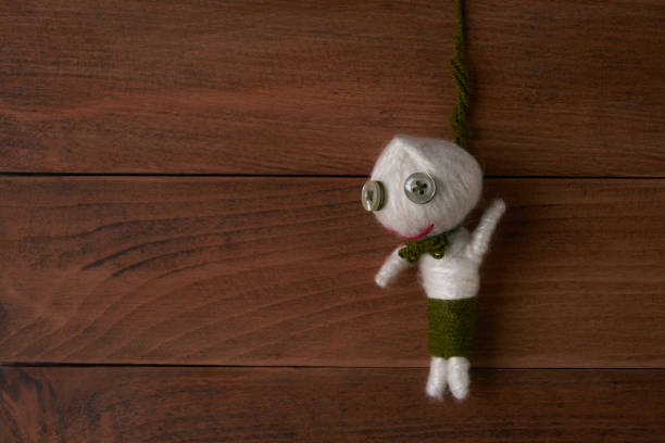 istock Hanged voodoo doll on wooden background. 643113916