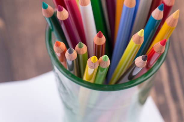 istock Multicolored pencils in a glass on wooden background 643116074