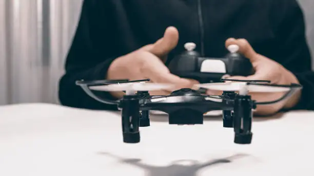 Photo of Boy Playing With A Small Quadrocopter Drone Close-up.