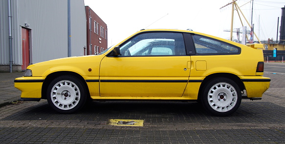 Den Helder, The Netherlands - February 19, 2017: Yellow HONDA Civic Coupe CRX 1.6I 16V parked in a public parking lot. Nobody in de vehicle.