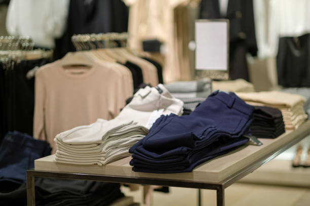 istock Pile of modern trousers of different colors on table 643149016