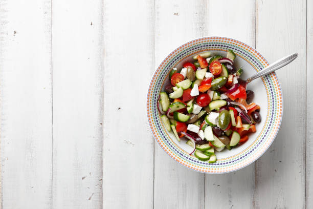 ensalada griega sobre fondo blanco de madera - mediterranean cuisine salad olive oil tomato salad fotografías e imágenes de stock