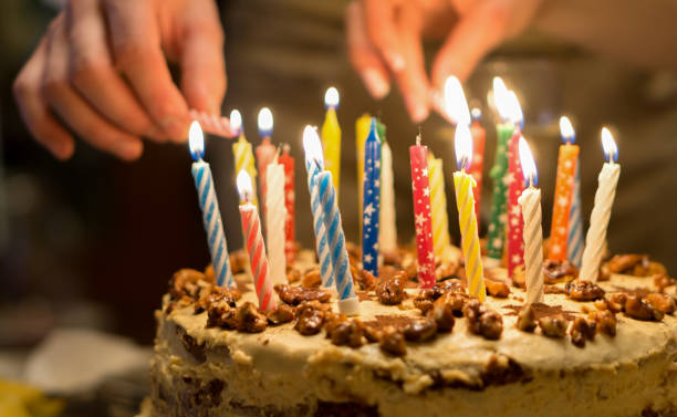 誕生日のろうそく 彼の 69 歳の誕生日ケーキに高齢男性年金受給者照明キャンドルの手