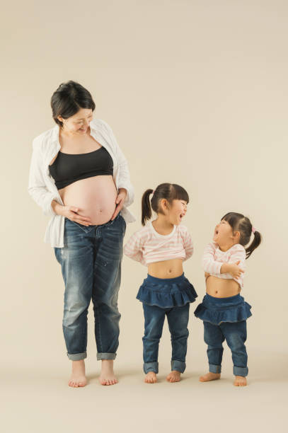 istock Pregnant mother and two sisters in studio 643211514