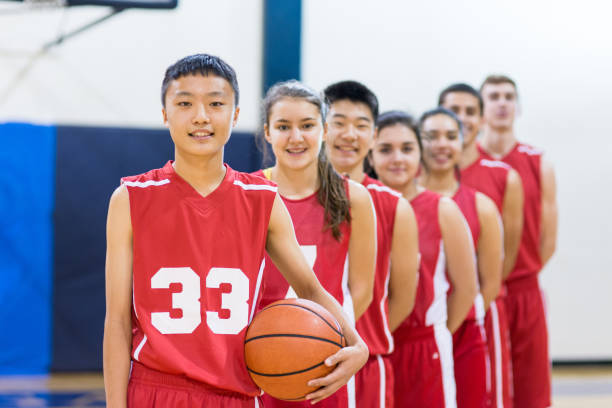 istock Mixed gender high school basketball team posing 643235338