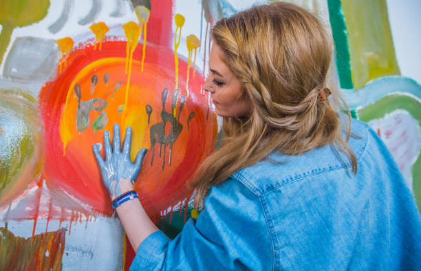 istock Blonde girl painting with hands 643242540