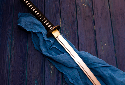 Espada katana de Japón en el fondo de madera con el chal azul photo
