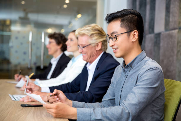 istock Happy Asian businessman sitting at conference 643258308