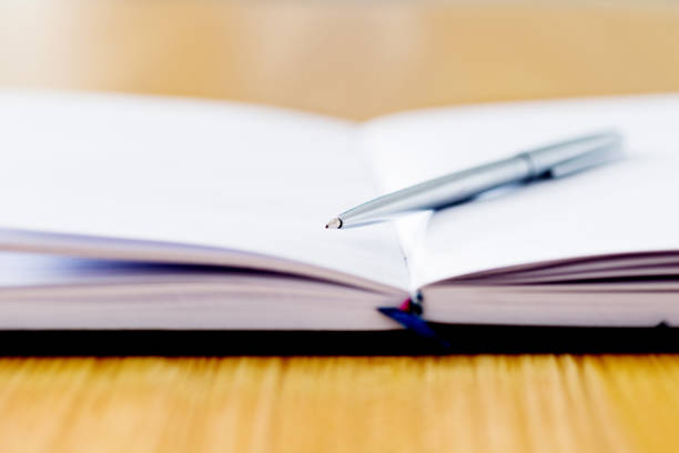 Spiral notebook and a pen on desk.