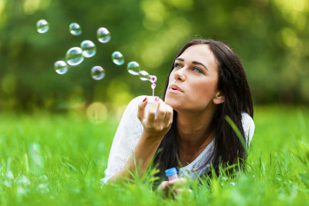 istock Beautiful woman blowing bubbles 643265012