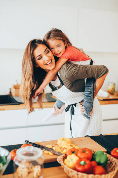 istock Mother giving her daughter a piggyback ride 643268500