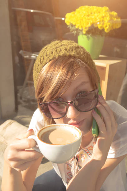 istock Young hipster woman drinking coffee and using her cellphone outdoors. 643275704