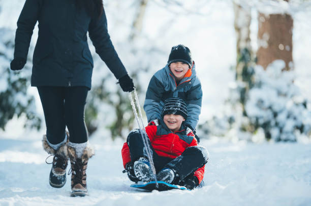 istock Mom and sons playing in snow 643283042