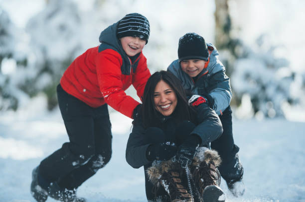 istock Mom and sons playing in snow 643283078