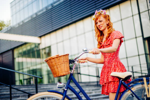 istock Beautiful redhead woman riding bicycle in summer 643289772
