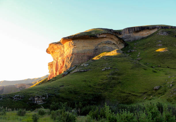 Brandwag Rock turns golden when the sun set - Golden Gate nature reserve - South Africa "Golden Gate" refers to the sandstone cliffs that are found on either side of the valley at the Golden Gate dam. In 1875, a farmer called J.N.R. van Reenen and his wife stopped here as they travelled to their new farm in Vuurland. He named the location "Golden Gate" when he saw the last rays of the setting sun fall on the cliffs. The park is situated in the Rooiberge of the eastern Free State, in the foothills of the Maluti Mountains. golden gate highlands national park stock pictures, royalty-free photos & images