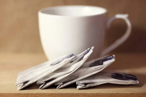 Cup and tea bags on table.