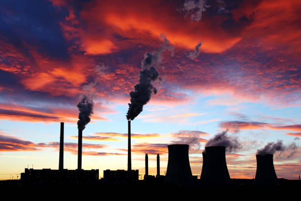 dramatic sunset on the sky and coal power plant factory stock photo