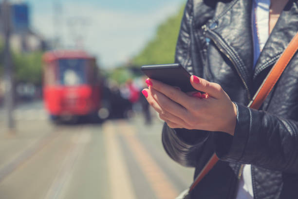istock Using cellphone with defocused city transportation station. 643293710