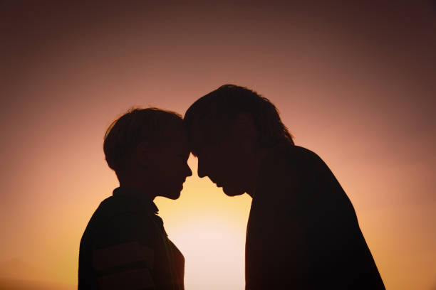 istock father and little son silhouettes at sunset 643297040