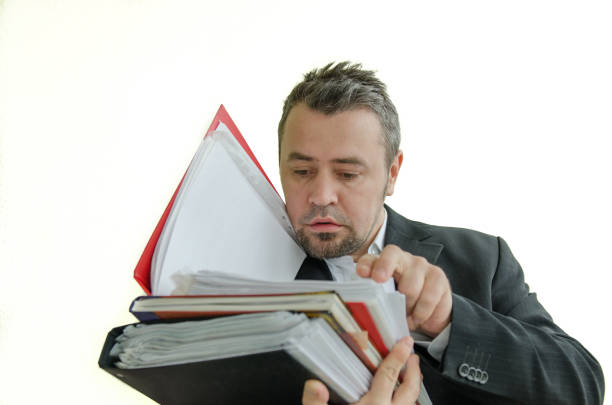 istock focused, serious businessman with folders in hand 643298038
